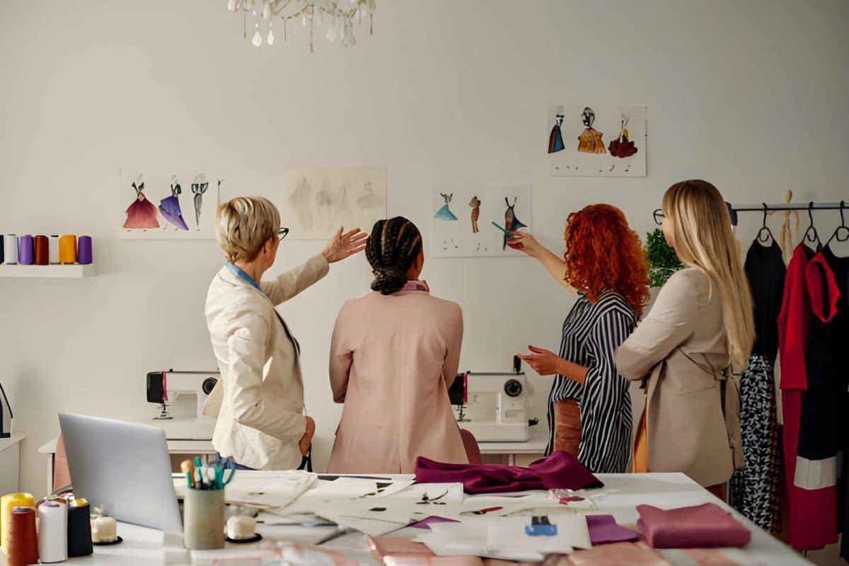 Vier Mitarbeiterinnen arbeiten an ihrem Modedesign