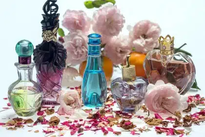 Wollen mantel en zijden sjaal op tafel met parfum in zachte lichtval