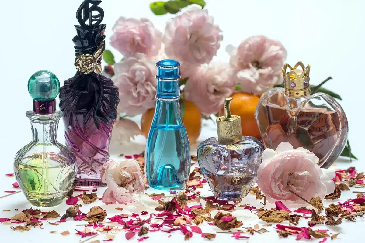 Wollen mantel en zijden sjaal op tafel met parfum in zachte lichtval
