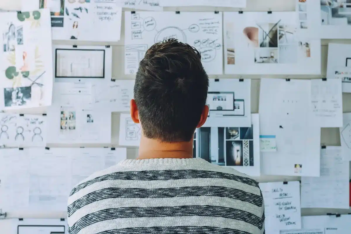 Grafisch ontwerper werkt aan magazine-layout met schetsen en scherm