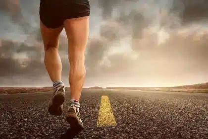 Silhouet van een loper op een pad waar gravel en asfalt samenkomen
