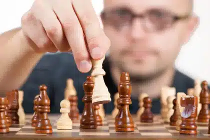 Schaduwrijke filmstudio met schaakbord en onopvallende jassen, symbolisch voor antagonisme