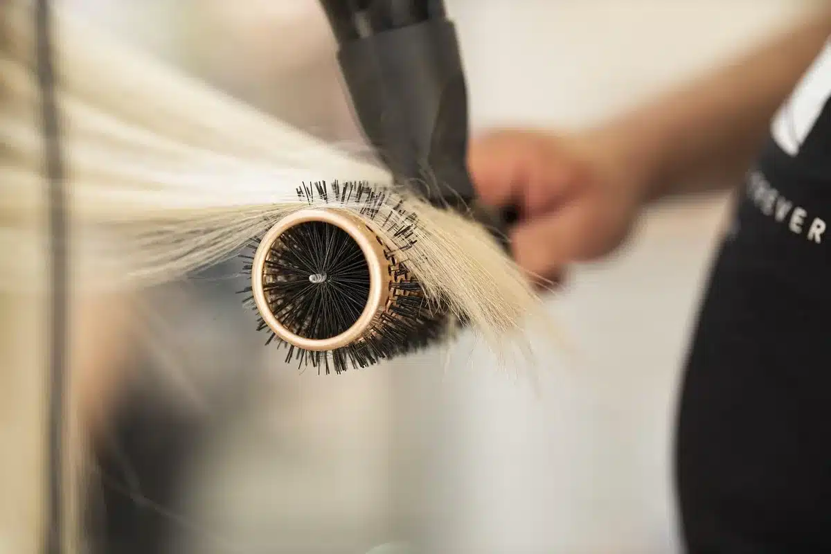 Handen die textuurspray en pomade gebruiken om losse plukjes te vormen